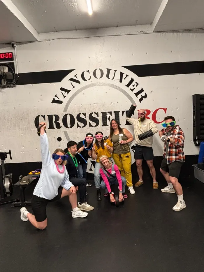 CrossFit BC members lined up under the gym wall logo after class