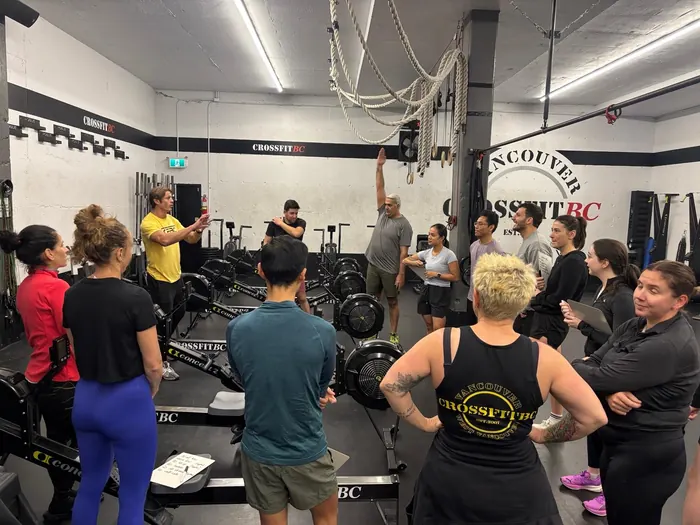 Three CrossFit BC members training together near the rings