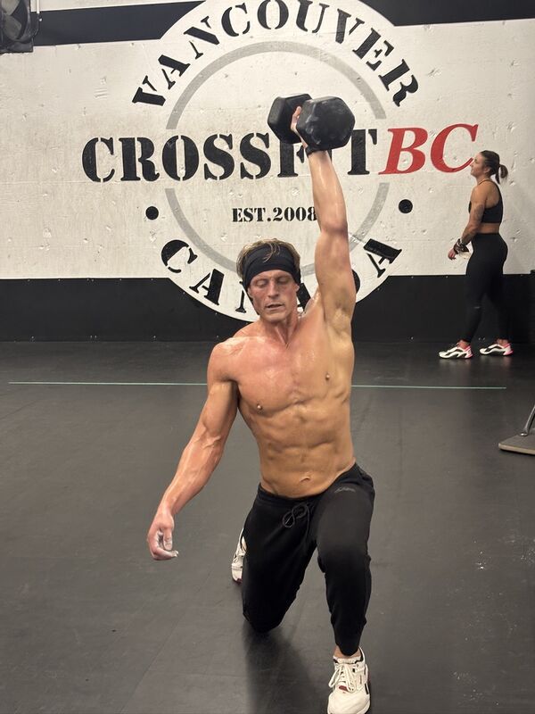 A coach guiding a member through a movement at CrossFit BC