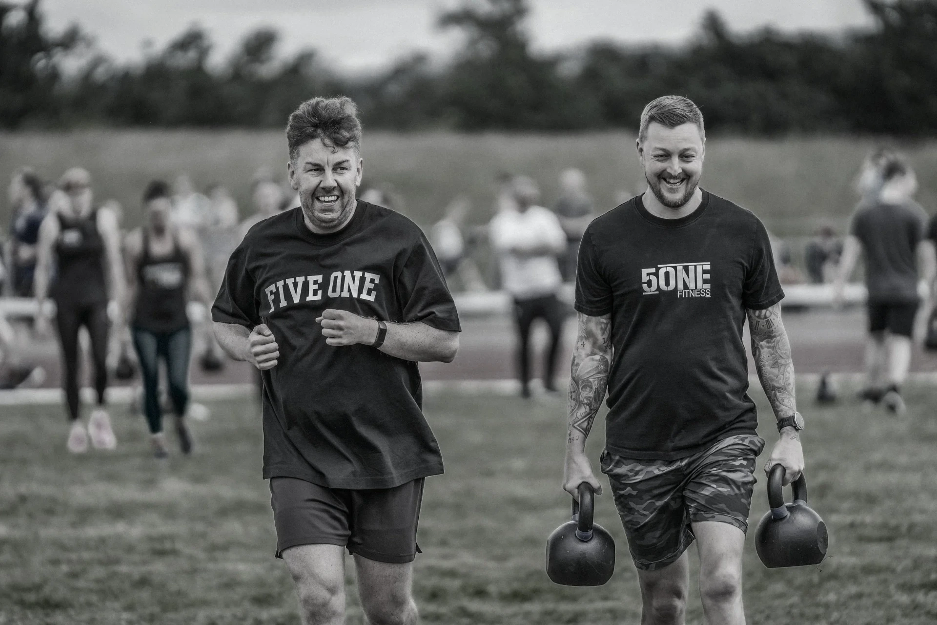 Athletes running and carrying kettlebells at a Deadly Dozen event